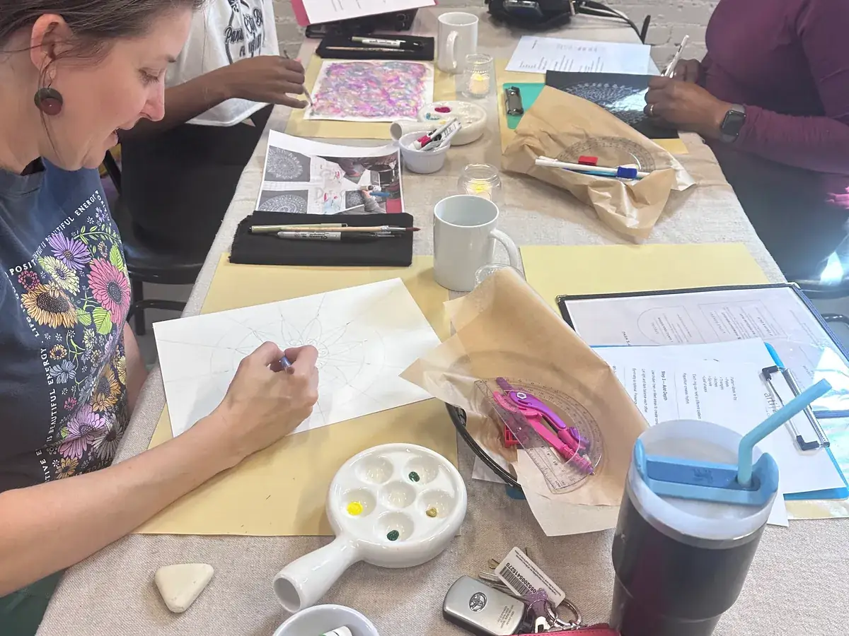 Guests working on art projects together at the ArtiZen Creative Café table