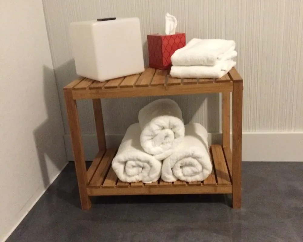 Rolled towels stocked in a JaxZen shower room